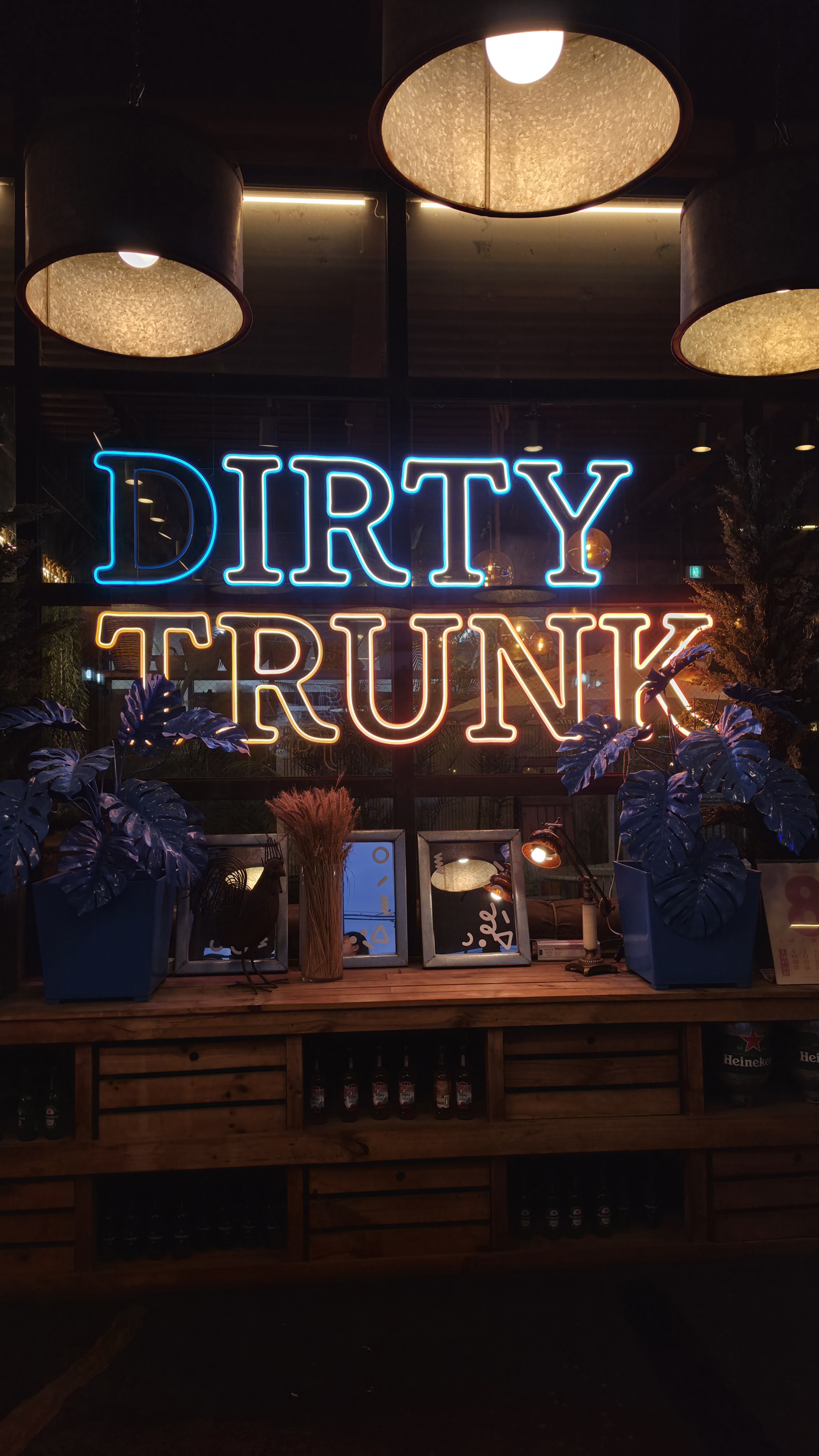 Biển neon DIRTY TRUNK trong nhà Dirty Trunk với đèn thả và trang trí cây