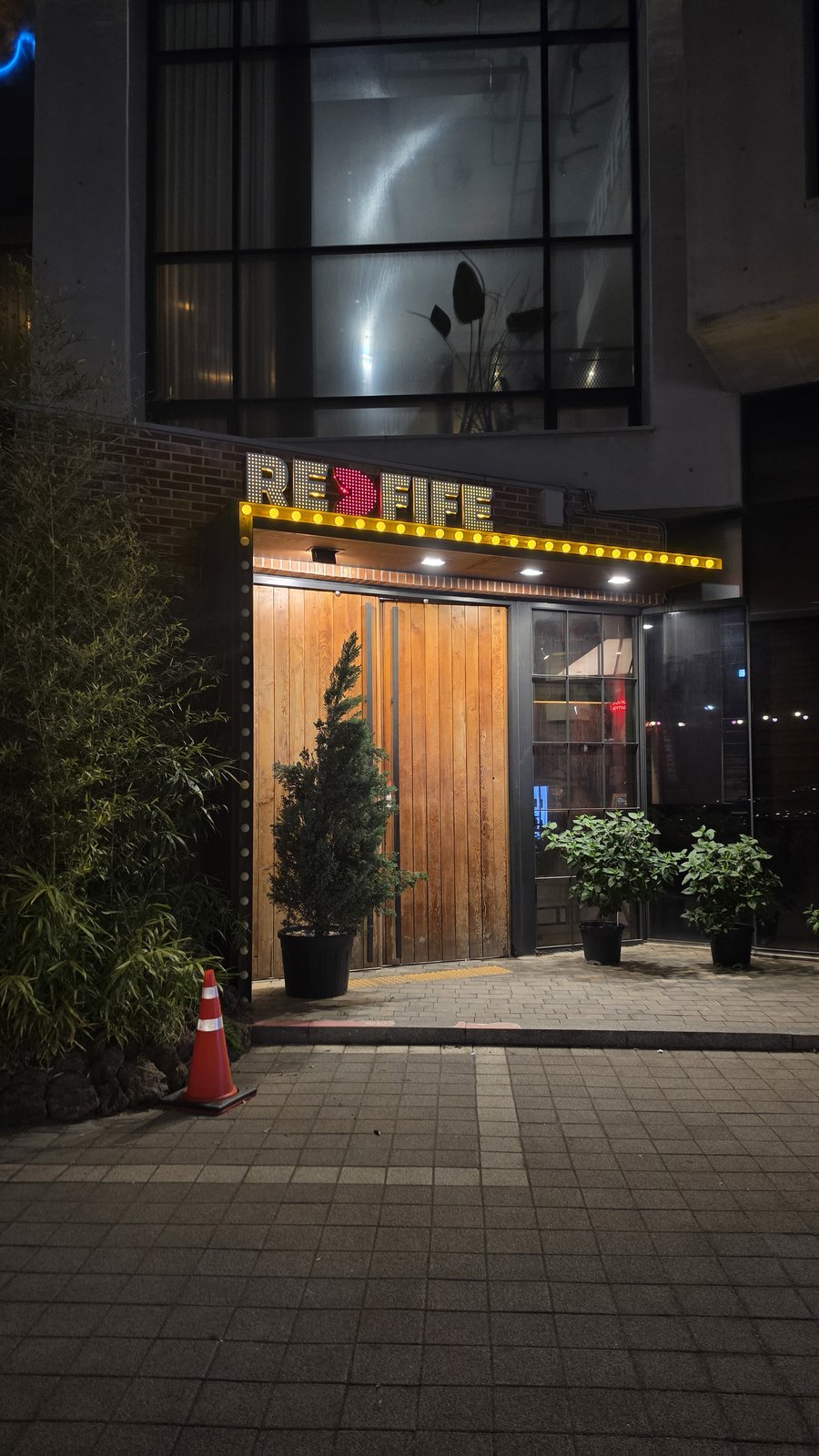 레드파이프 외부 데크와 노란 LED REDFIFE 사인 야경