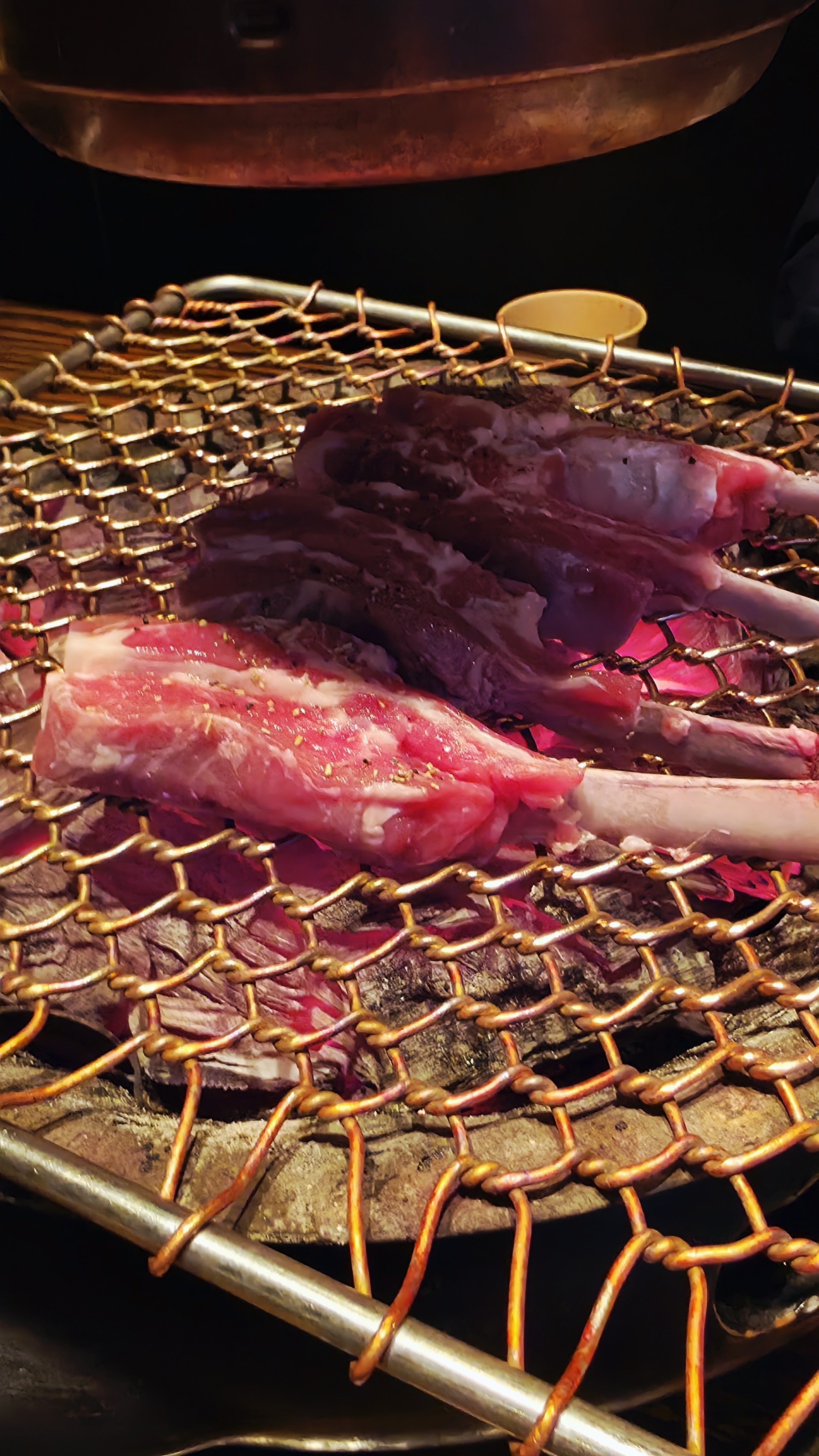 경사진 그물망 그릴에 걸친 양갈비 굽기